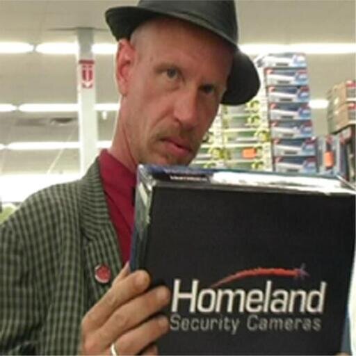 Chris Chandler reading a box that says Homeland security Cameras